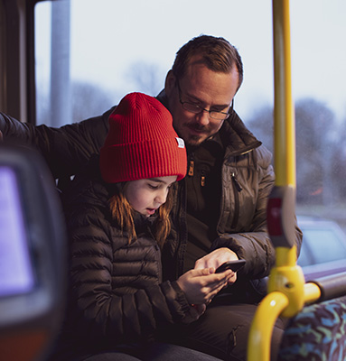 Ett barn och en medelålders man ombord på en buss, bild